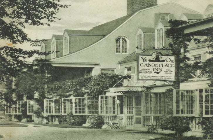 Historic image of original Canoe Place Inn with classic hanging sign.
