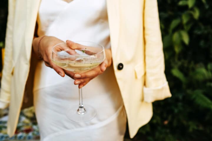 Woman holding a glass of champagne at a garden event at Canoe Place.