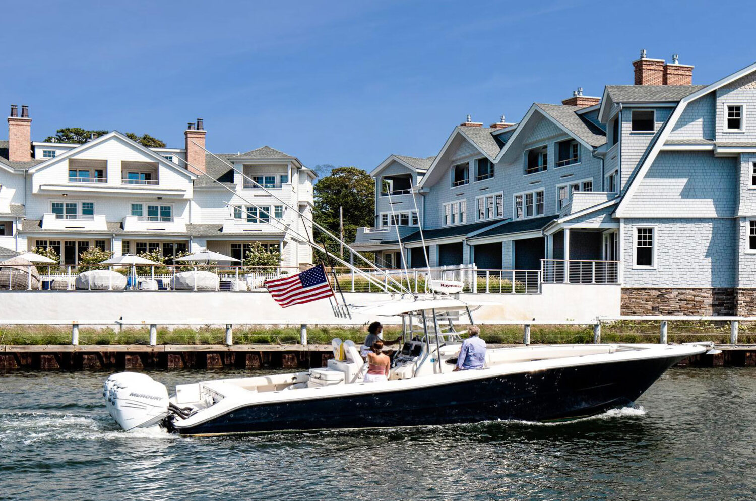 Exterior image of a fishing boat crossing in front of Canoe Place Boathouses.