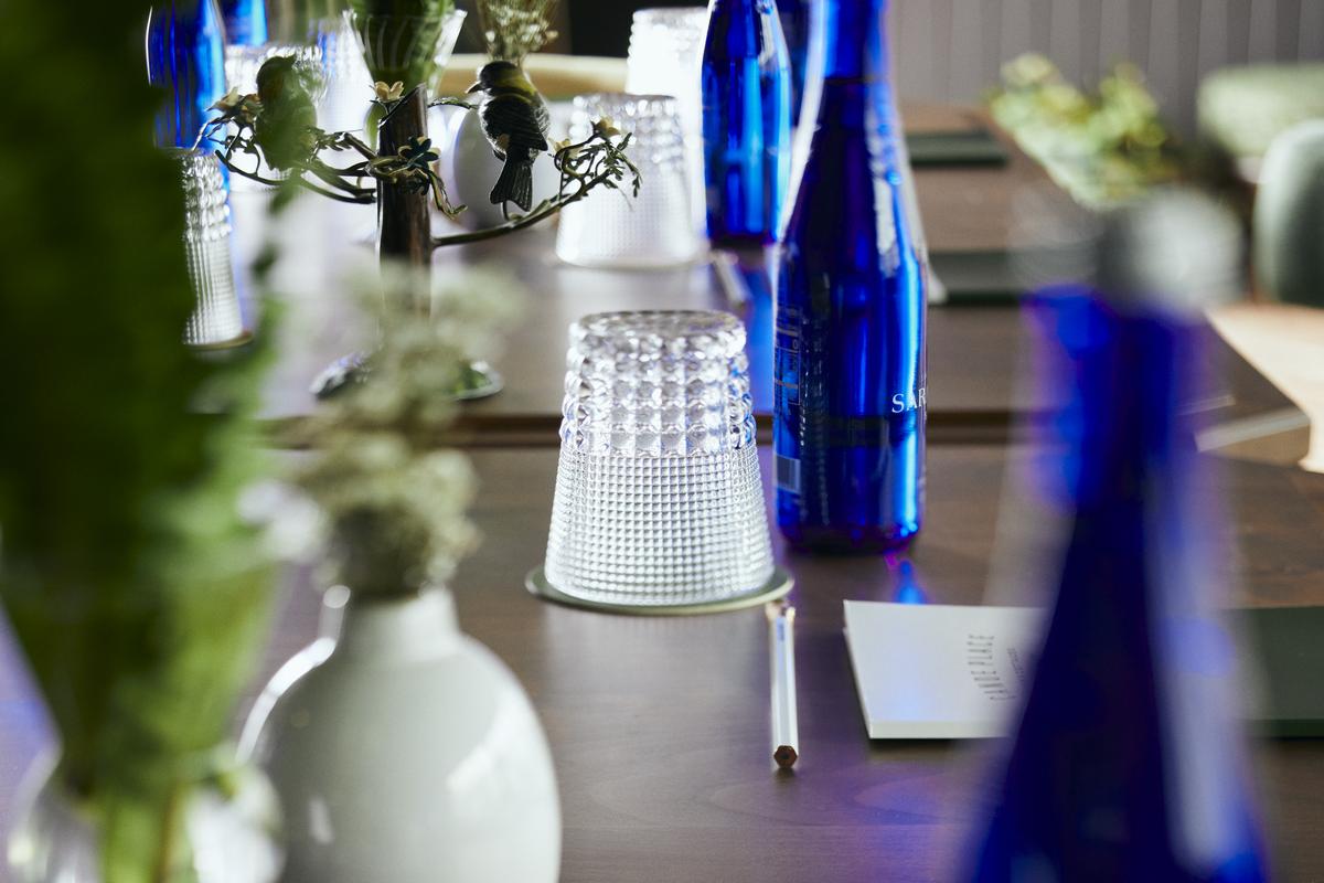 Table with cups, water, pens, and notebook