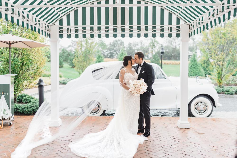 Bride and groom kissing at Canoe Place entrace