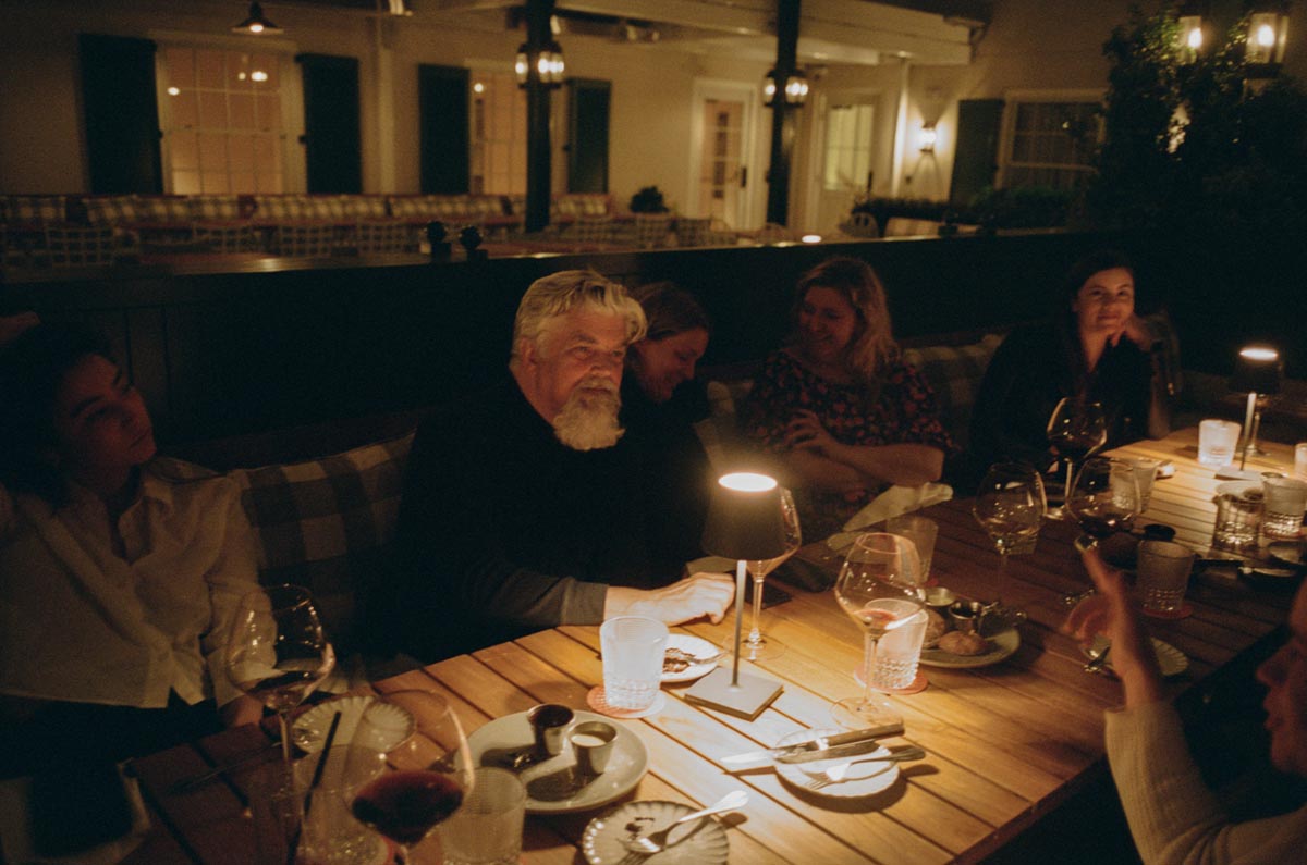 People dining outdoors at night with tamps