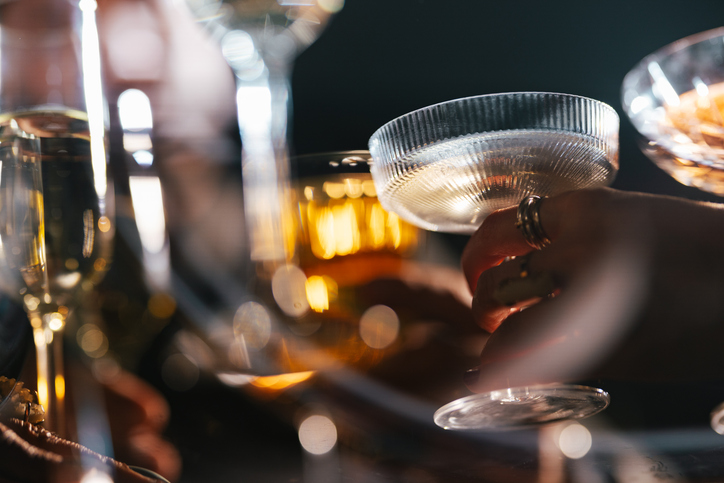 Low angle view of unrecognizable group of multi-ethnic friends having fun while toasting with a wine and champagne at Christmas party.